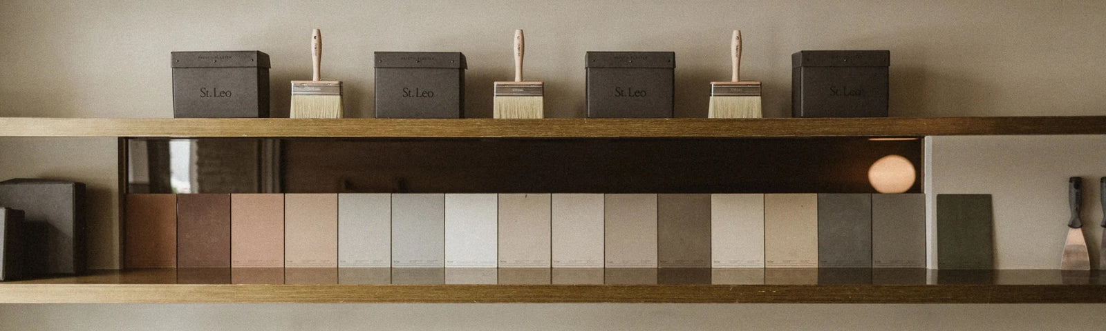 St. Leo paint tins, brushes, and Dolomite Plaster colour swatches on a shelf in the Atelier. Senseware studio